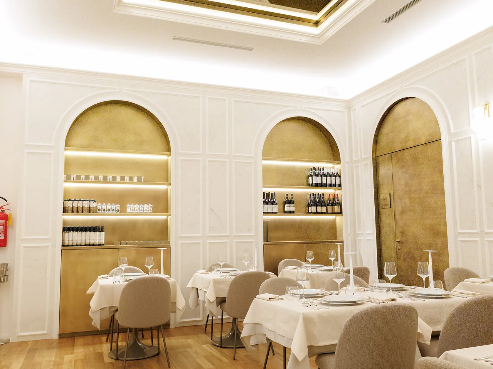 La sala, fra la boiserie chiara e i pannelli in ottone